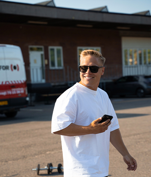 Coachen er udenddørs smilende med solbriller